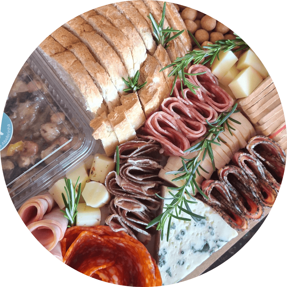 detalhe de tábua de frios ou platter, contendo charcutaria fina, salaminho, queijos, antepastos, torradas, nuts e frutas.